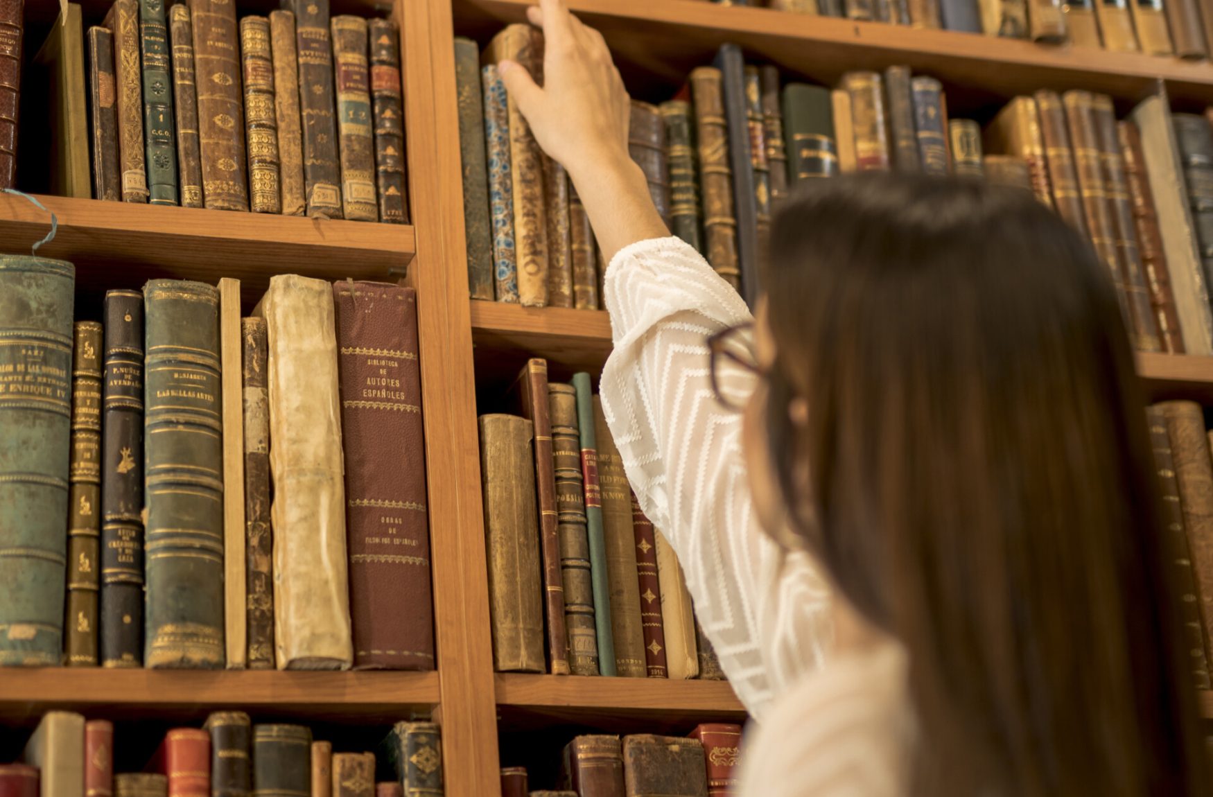 excellent-female-student-choosing-vintage-book-library